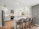 Bright kitchen with white cabinets, stainless steel appliances, a tile backsplash, and bar seating at 12217 Snead Pl, Tampa, FL 33624