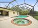 A stunning screened in pool and jacuzzi offers the best in backyard relaxation and entertainment at 12217 Snead Pl, Tampa, FL 33624