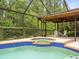 Screened pool with a connected spa, outdoor seating area and covered patio with a ceiling fan at 12217 Snead Pl, Tampa, FL 33624