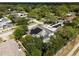 Aerial shot of the property shows a pool, basketball court, large solar panels, and mature trees at 1326 Moss Dr, Dunedin, FL 34698