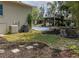 Backyard showcases a basketball court, covered seating, landscaping, and air conditioning units at 1326 Moss Dr, Dunedin, FL 34698