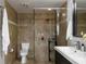 Well-lit bathroom featuring a glass shower, toilet, dark vanity with a sink, and a mirror at 1326 Moss Dr, Dunedin, FL 34698