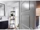 Bright bathroom featuring a dark vanity, a mirror, decorative shelves, and a partial view of an upholstered chair at 1326 Moss Dr, Dunedin, FL 34698