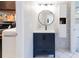 Modern bathroom vanity with round mirror, stylish tiles, and attached laundry room at 1326 Moss Dr, Dunedin, FL 34698