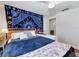 Cozy bedroom featuring a comfortable bed, ceiling fan, and unique wall decorations, perfect for relaxation and sleep at 1326 Moss Dr, Dunedin, FL 34698