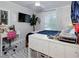 Bright bedroom featuring a desk, TV, and comfortable bed, creating a cozy and functional living space at 1326 Moss Dr, Dunedin, FL 34698