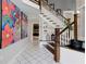 Welcoming entryway with art, tile flooring and wood and white staircase at 1326 Moss Dr, Dunedin, FL 34698