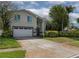 Charming two-story home featuring a two-car garage, well-maintained lawn, and lush landscaping at 1326 Moss Dr, Dunedin, FL 34698