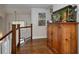 Hallway with wood flooring, staircase, and a large wooden cabinet with fish tank at 1326 Moss Dr, Dunedin, FL 34698