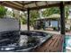 Relax in the outdoor hot tub with views of the patio, pool, and cabana at 1326 Moss Dr, Dunedin, FL 34698