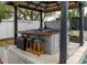 An outdoor hot tub under a pergola with stools for relaxing outside at 1326 Moss Dr, Dunedin, FL 34698