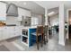 Kitchen with blue island, seating, stainless steel appliances, and an open view of the dining area at 1326 Moss Dr, Dunedin, FL 34698