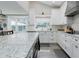 Bright, modern kitchen features white cabinetry, an island with unique countertops, and stainless steel appliances at 1326 Moss Dr, Dunedin, FL 34698