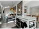 Open-concept kitchen and dining area boasts an island with seating, stainless steel appliances, and modern decor at 1326 Moss Dr, Dunedin, FL 34698