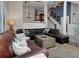Spacious living room with large leather couches, ceiling fan, and staircase at 1326 Moss Dr, Dunedin, FL 34698
