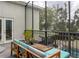 Charming screened patio featuring cozy seating, potted plants, and views of the backyard and pool, ideal for outdoor relaxation at 1326 Moss Dr, Dunedin, FL 34698