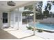 The screened-in patio provides a view of the outdoor kitchen, cabana, and pool area at 1326 Moss Dr, Dunedin, FL 34698
