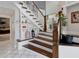 Staircase featuring white risers, wood treads, storage shelves, and light tile flooring at 1326 Moss Dr, Dunedin, FL 34698