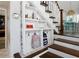 Under stair storage solution with shelves, hooks, and tile flooring at 1326 Moss Dr, Dunedin, FL 34698