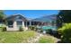 A beautifully landscaped backyard featuring a pool and screened enclosure at 14324 Bronte Ct, Hudson, FL 34667