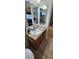 Bathroom vanity with tiled countertop, decorative mirrors, and warm wood cabinetry at 14324 Bronte Ct, Hudson, FL 34667