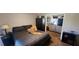 Bedroom with queen-sized bed, dark furnishings, and view into connected living space at 14324 Bronte Ct, Hudson, FL 34667
