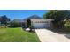 Charming single-story home boasts a manicured lawn and a two-car garage at 14324 Bronte Ct, Hudson, FL 34667