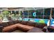 Enclosed patio with outdoor seating overlooking a pool and lush landscaping at 14324 Bronte Ct, Hudson, FL 34667