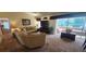 Spacious carpeted living room featuring a comfortable sofa, sliding glass door, and cozy furnishings at 14324 Bronte Ct, Hudson, FL 34667