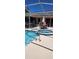 Inviting screened pool and spa with outdoor dining area and a cozy bar setup, perfect for relaxation at 14324 Bronte Ct, Hudson, FL 34667