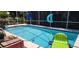Wide screened pool with clear blue water and a vacuum, and poolside floats at 14324 Bronte Ct, Hudson, FL 34667
