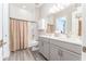 Bathroom with dual sink vanity, wood-look floors, and a shower-tub combination at 148 Mossy River Ct, Brandon, FL 33511