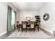 Charming dining room featuring a modern chandelier, tray ceiling, and view of the elegant backyard at 148 Mossy River Ct, Brandon, FL 33511