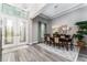 Formal dining room with tray ceiling, chandelier, and wood-look tile flooring is perfect for entertaining at 148 Mossy River Ct, Brandon, FL 33511