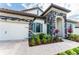 Beautiful home exterior with stone accents, lush landscaping, and a brick paver driveway leading to the garage at 148 Mossy River Ct, Brandon, FL 33511
