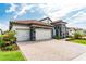 Beautiful single-story home featuring a tile roof, a paver driveway, manicured lawn and beautiful landscaping at 148 Mossy River Ct, Brandon, FL 33511