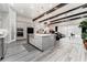 Modern kitchen with stainless steel appliances, gray cabinetry, a large island, and wood beams at 148 Mossy River Ct, Brandon, FL 33511