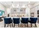 Bright kitchen island boasts pendant lighting and stylish blue seating for a modern look at 148 Mossy River Ct, Brandon, FL 33511