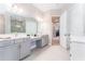 Bright main bathroom features a dual sink vanity, bright tile, and linen closet at 148 Mossy River Ct, Brandon, FL 33511