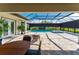 Covered outdoor patio with dining and seating overlooking the sparkling screened-in pool at 148 Mossy River Ct, Brandon, FL 33511