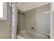 Close-up of a tile-walled bathtub and shower area with a neutral curtain at 1516 Lemon St, Clearwater, FL 33756