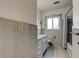 Grey bathroom with patterned tile floor, tile walls, and a bathtub at 1516 Lemon St, Clearwater, FL 33756