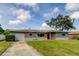 Charming single-story home with attached garage and well-manicured lawn at 1516 Lemon St, Clearwater, FL 33756