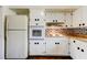 Kitchen featuring white appliances and cabinets, with a unique brick backsplash at 1516 Lemon St, Clearwater, FL 33756