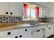 Bright kitchen showcasing white cabinets, brick backsplash, and stainless steel sink under a window at 1516 Lemon St, Clearwater, FL 33756