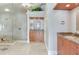 Bathroom with granite countertops, double sinks, and a tiled glass shower at 17382 Kennedy Dr, North Redington Beach, FL 33708