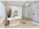 Bright bathroom featuring a soaking tub and a glass enclosed shower with neutral tones at 17382 Kennedy Dr, North Redington Beach, FL 33708