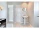 Bright bathroom features a pedestal sink, glass enclosed shower, and neutral tones at 17382 Kennedy Dr, North Redington Beach, FL 33708