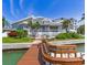 Waterfront home featuring a private dock, lush landscaping, and a spacious outdoor patio with gorgeous water views at 17382 Kennedy Dr, North Redington Beach, FL 33708