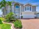 Elegant home with a spacious garage and a grand entrance framed by mature palm trees at 17382 Kennedy Dr, North Redington Beach, FL 33708